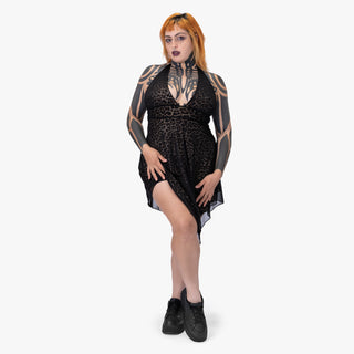 Woman wearing a black dress with sheer panels on a white background