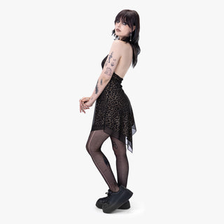 Model wearing a leopard print dress with sheer black tights on a white background