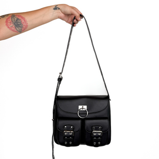 Black leather bag with silver buckles held by a hand on a white background