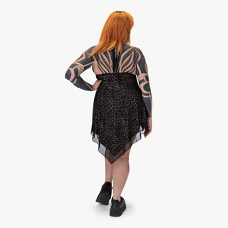Person wearing a black dress with leopard print and zebra pattern sleeves on a white background