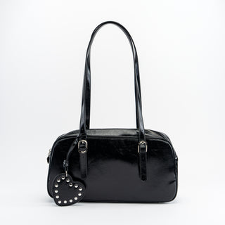 Black handbag with a heart-shaped keychain on a white background