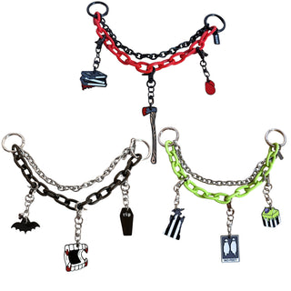 Three gothic-themed chain bracelets with charms are displayed on a solid white background. The top bracelet features red and black chains with a dagger, book, and skull charm.